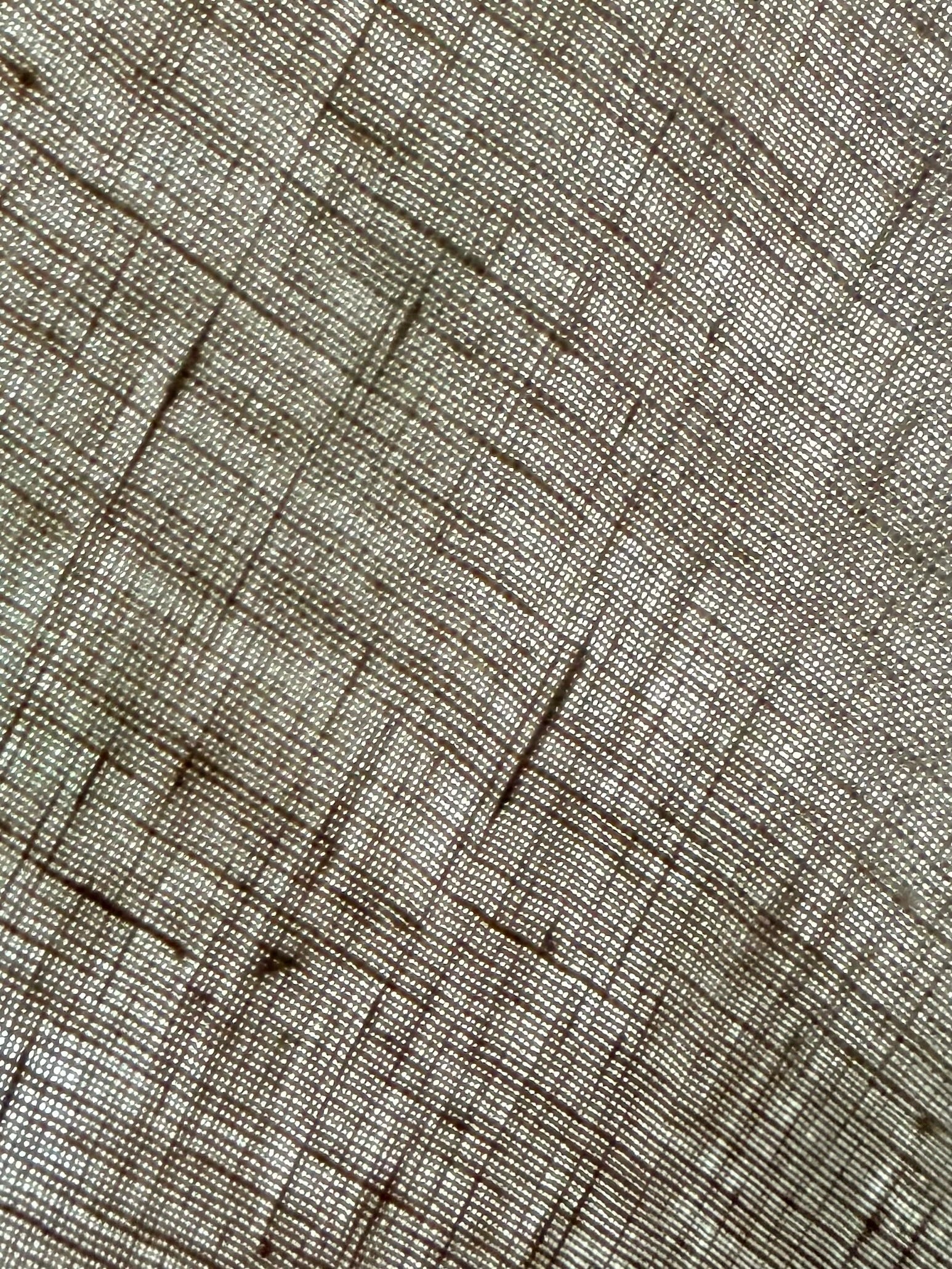 A close-up of a woven fabric texture with a fine grid pattern in beige and brown.
