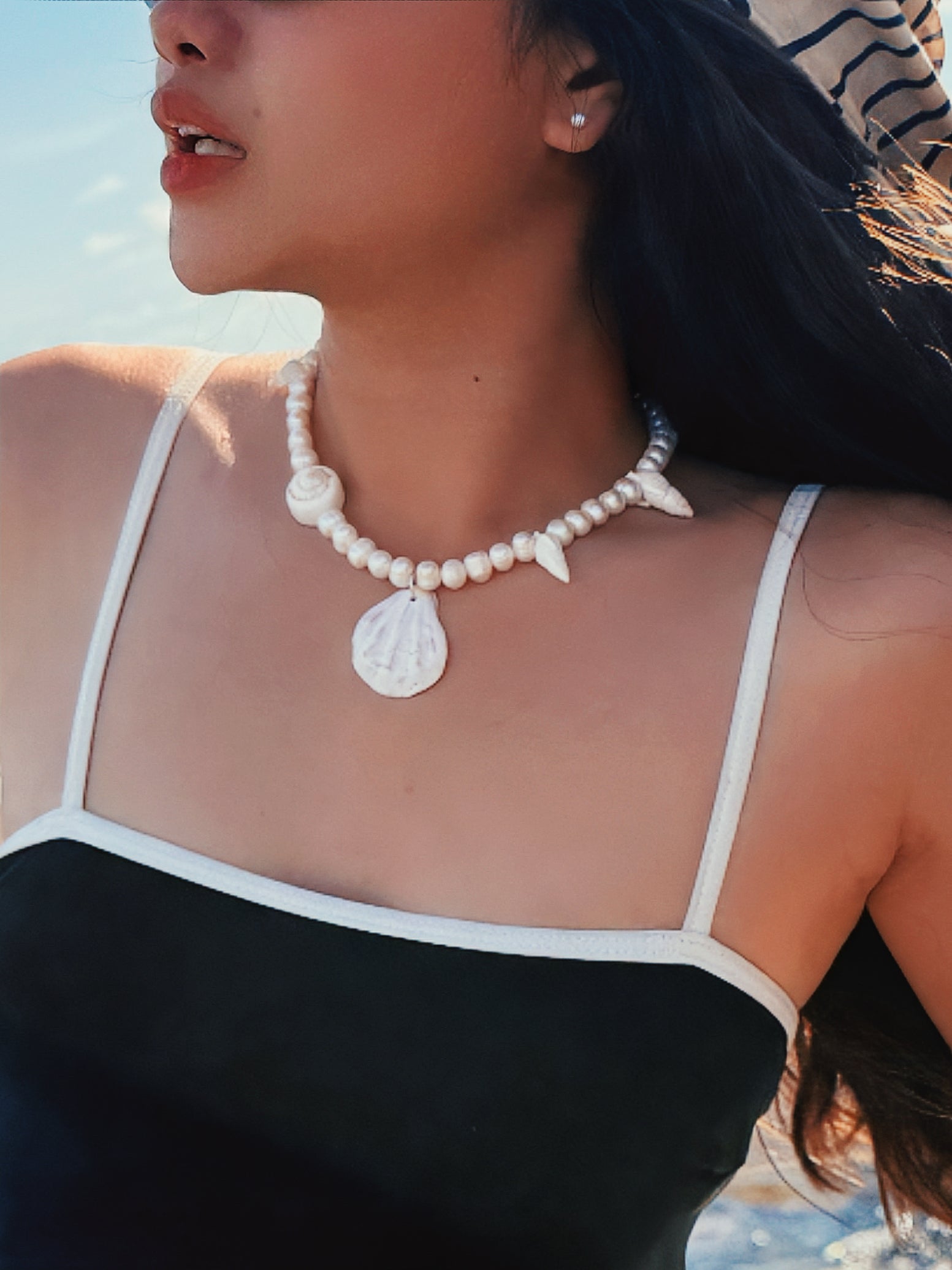 Model wearing the handmade Statement Seashell Pearl Choker, featuring natural freshwater pearls, real seashells, and tribal silver closure—styled as coastal boho jewelry, perfect for beach weddings, honeymoons, and resort wear.