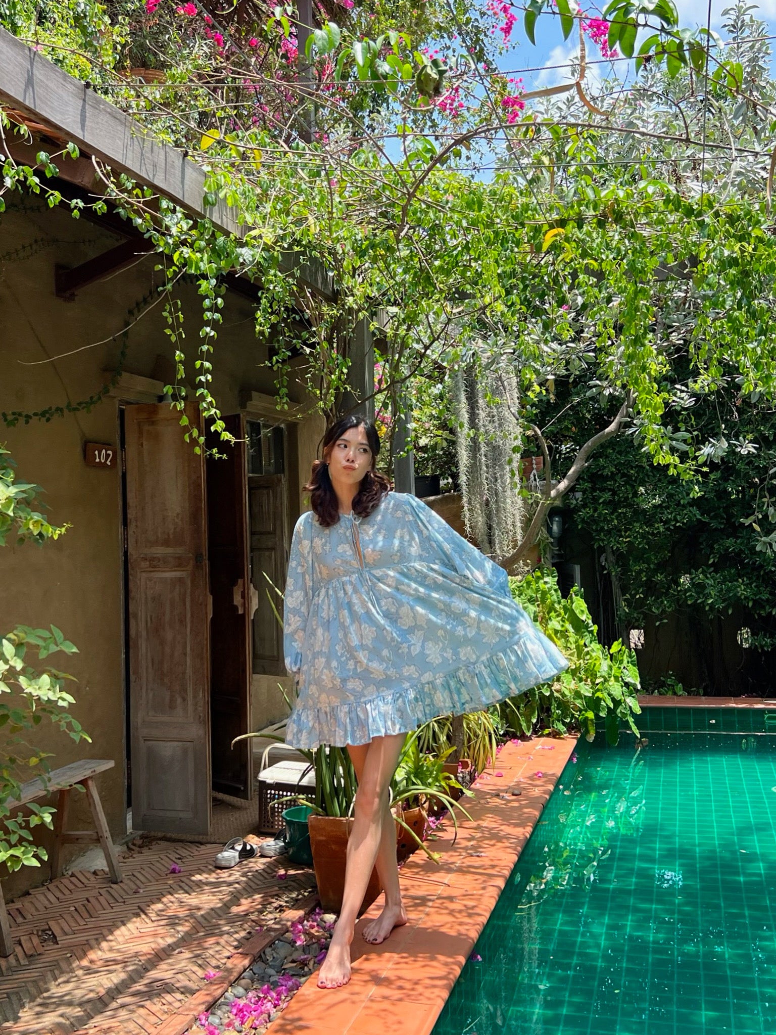 Shop Coco de Chom Lola Bohemian Mini Dress in Beautiful Blue Sky - A Truly Unique Limited Edition Piece. Handcrafted with Wooden Blocks on Fine Cotton Voile, Showcasing a Dreamy Block Printed Pattern Inspired by Bougainvillea Flowers and Vacations. Ideal for Beach Days, Vacations, and Boho Enthusiasts.