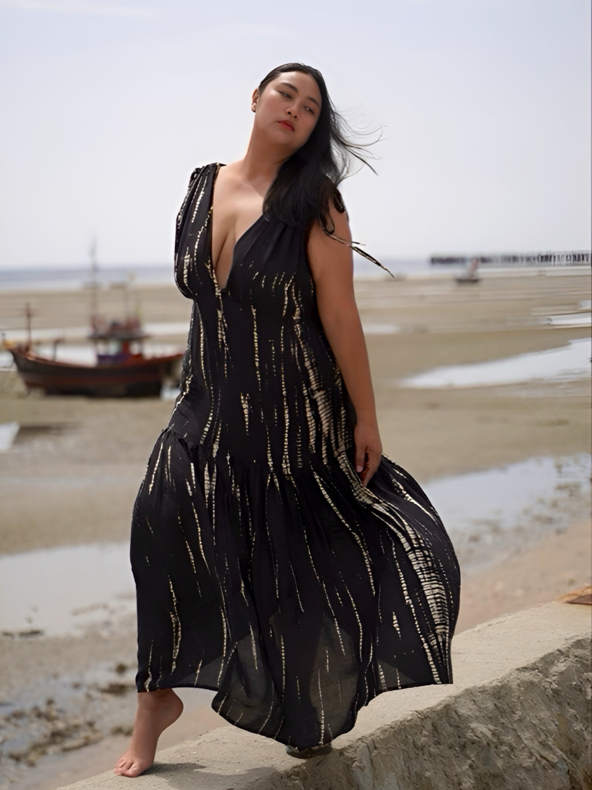 Model wearing a flowy, black tie-dye goddess kaftan dress with deep V-neckline and ruffled hem, handcrafted from soft rayon. Oversized boho kaftan designed for beachwear, resort lounging, or stylish everyday wear.