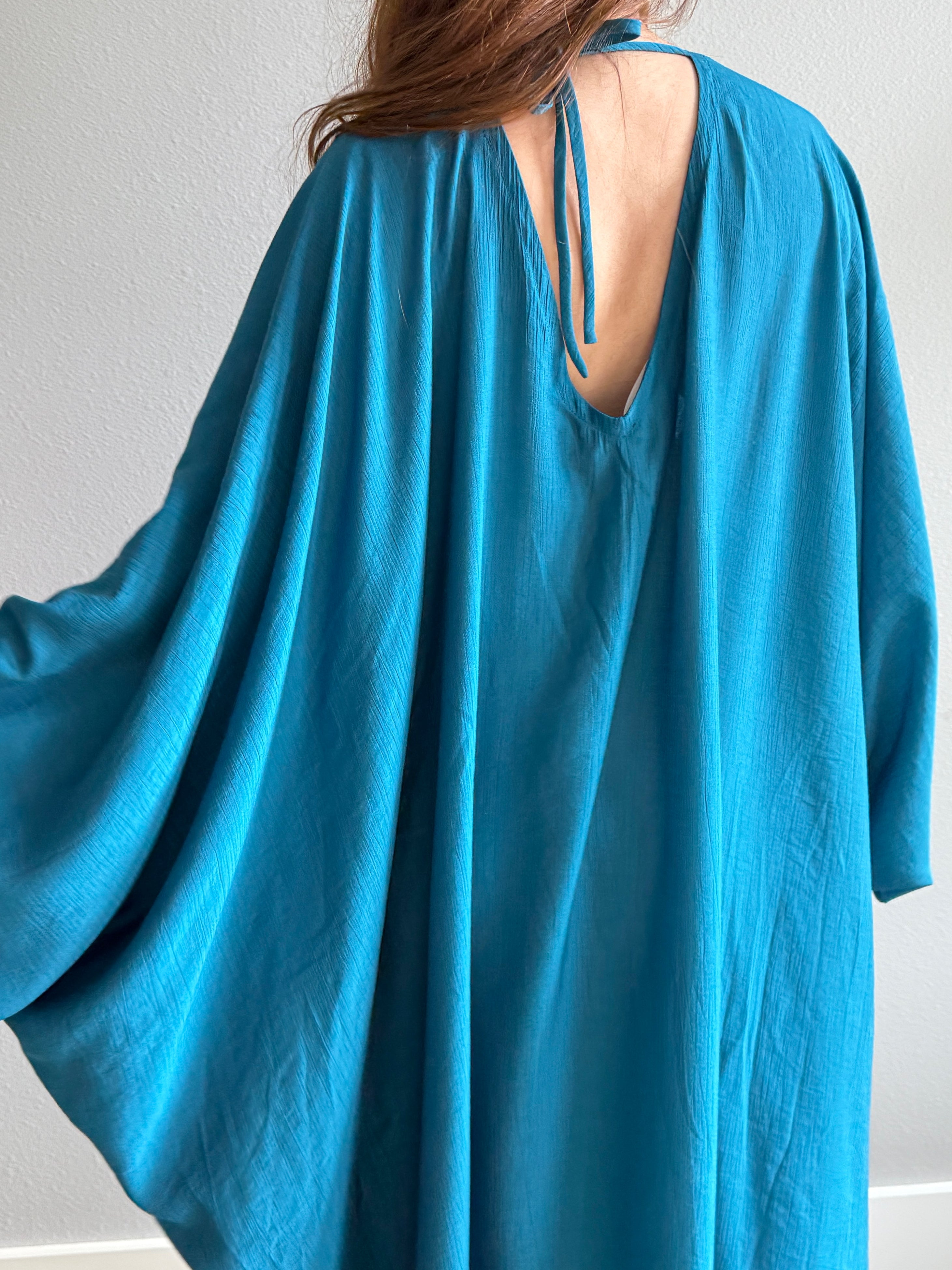 Zoom in teal Blue Kaftan maxi dress with open back on a plain background