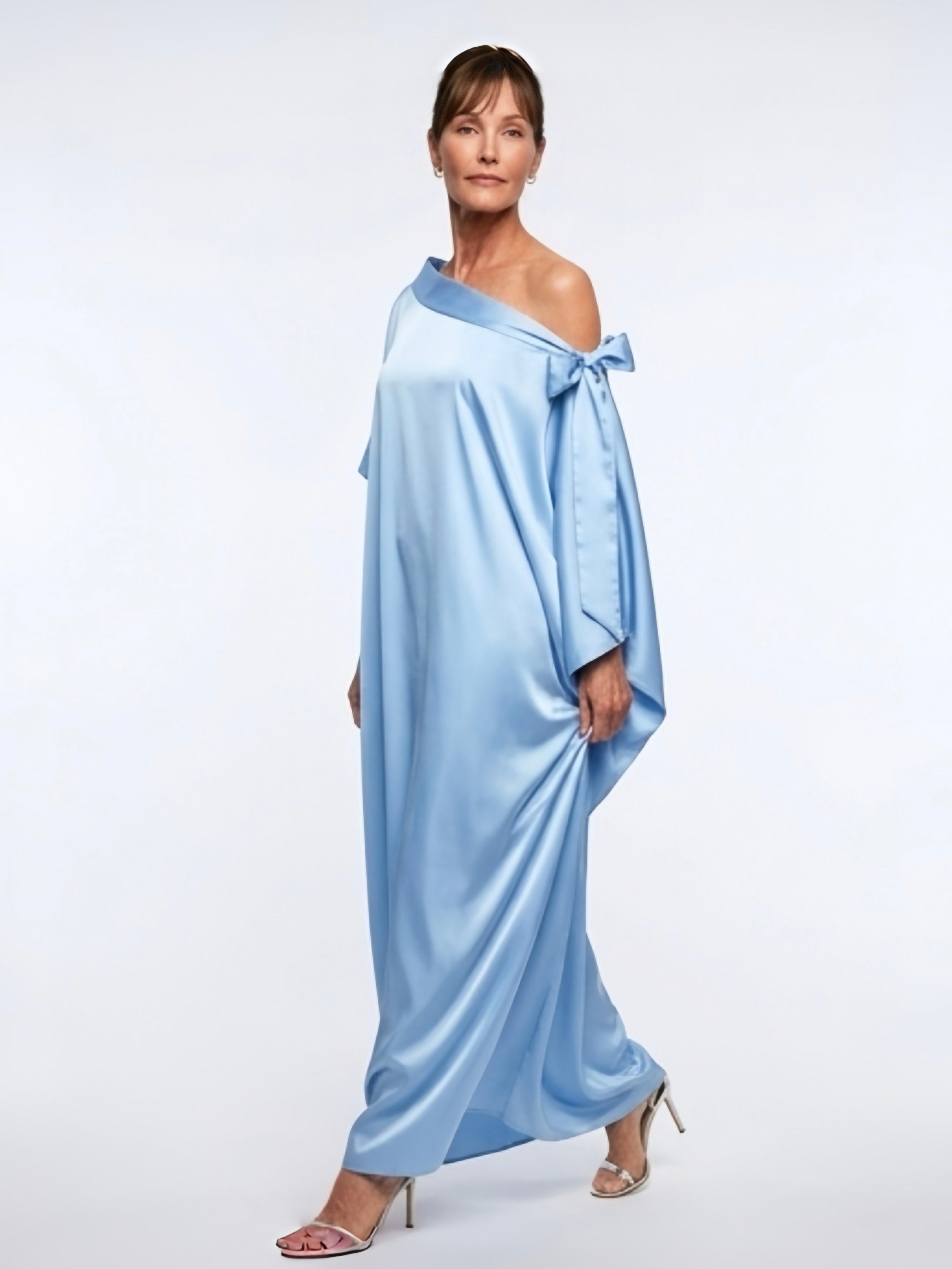 Woman wearing a sky blue off shoulder kaftan maxi dress with a flowy silhouette, styled as a beach wedding guest dress and resort wear by COCO DE CHOM