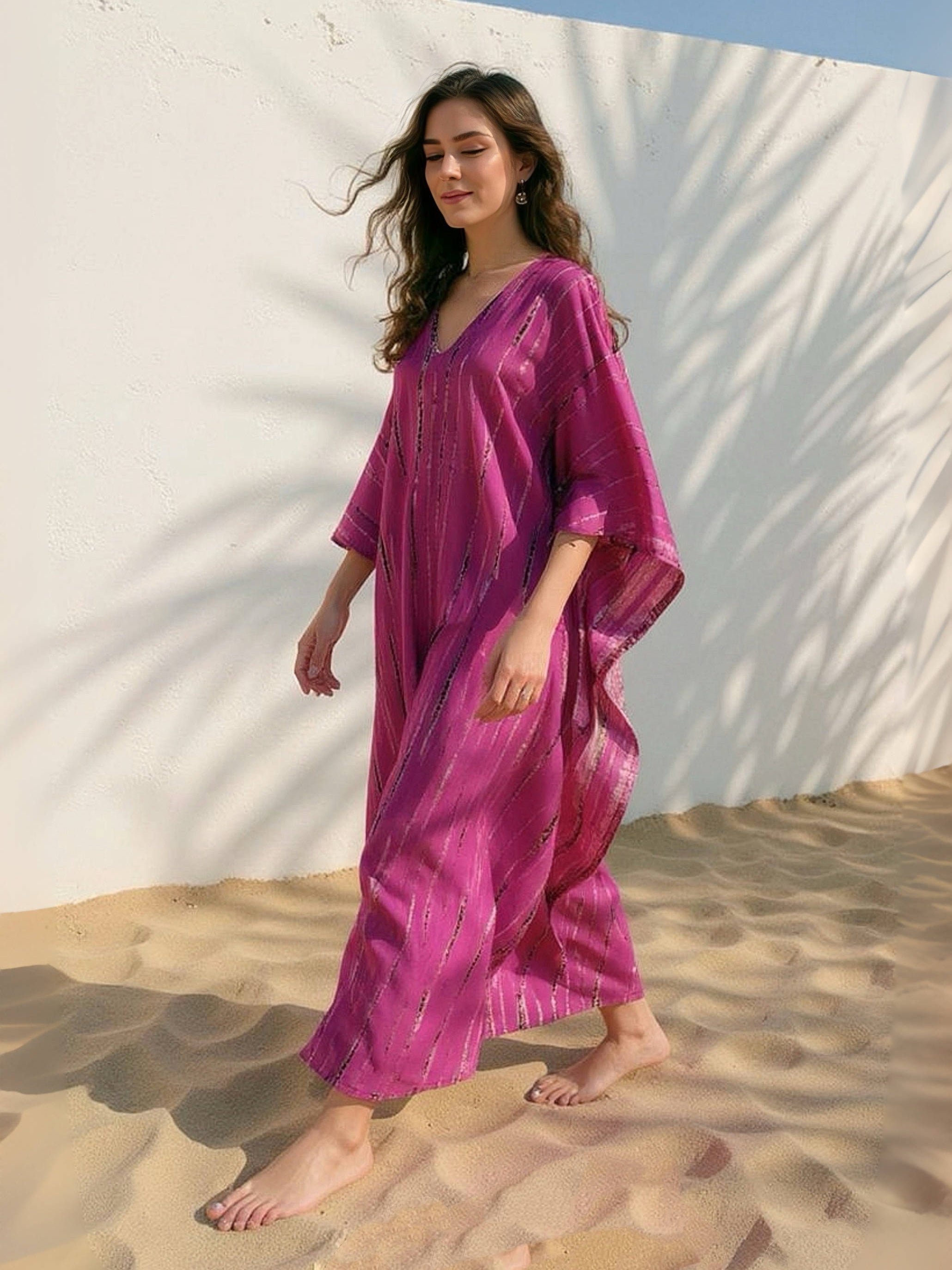 Woman wearing a handmade tie dye pink dress standing against a white wall with shadows, boho look