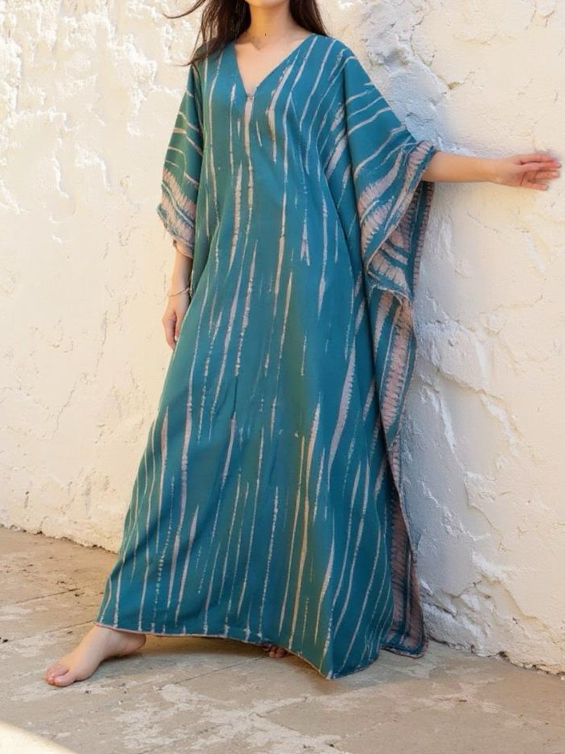 Model wearing a teal tie-dye boho caftan dress; long handmade kaftan perfect as a beach cover-up, vacation kaftan, or oversized resort wear for women. Ideal gift for her and great for lounging or bohemian beachwear style.