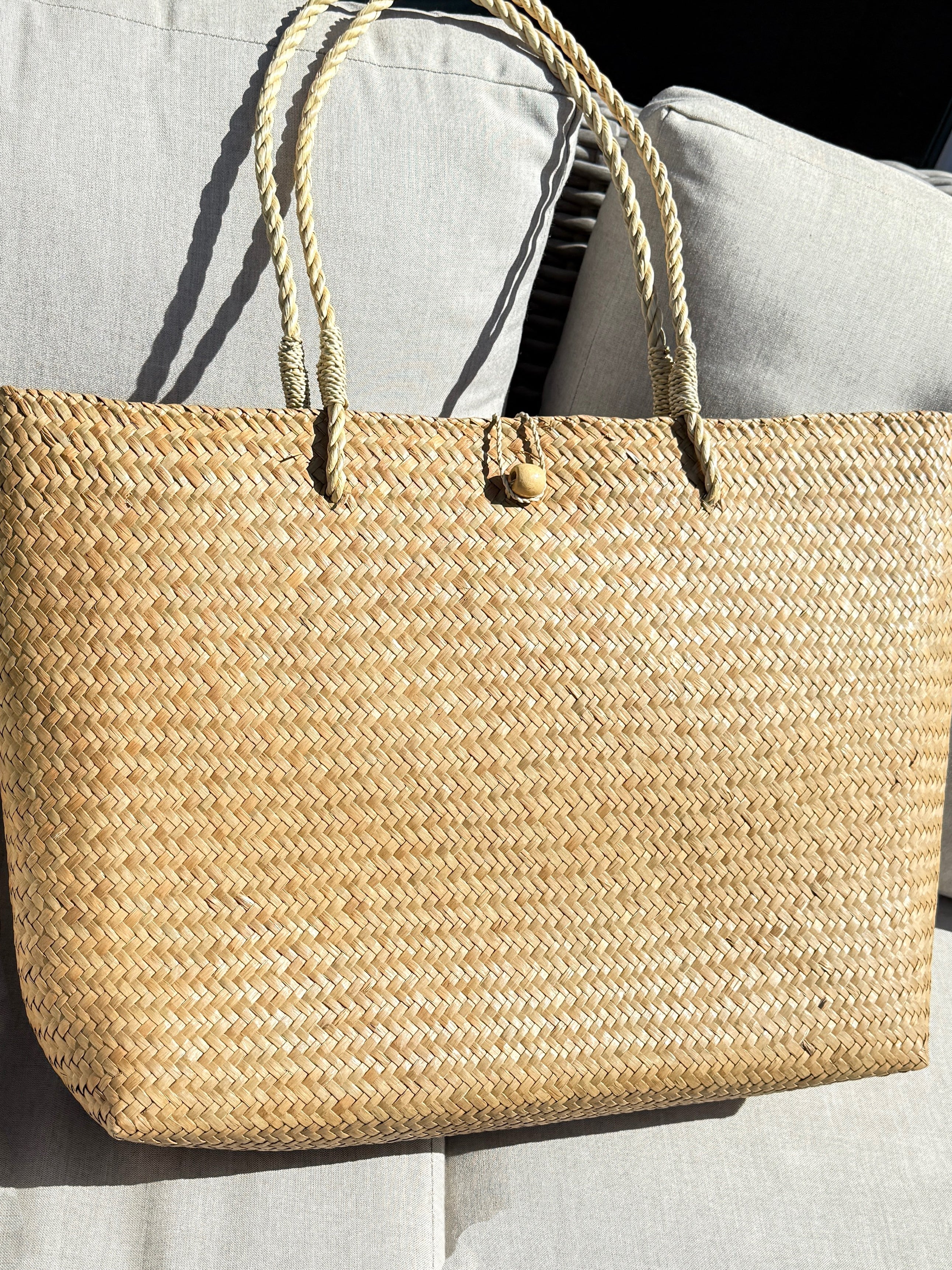 Oversized natural straw beach bag with button loop closure