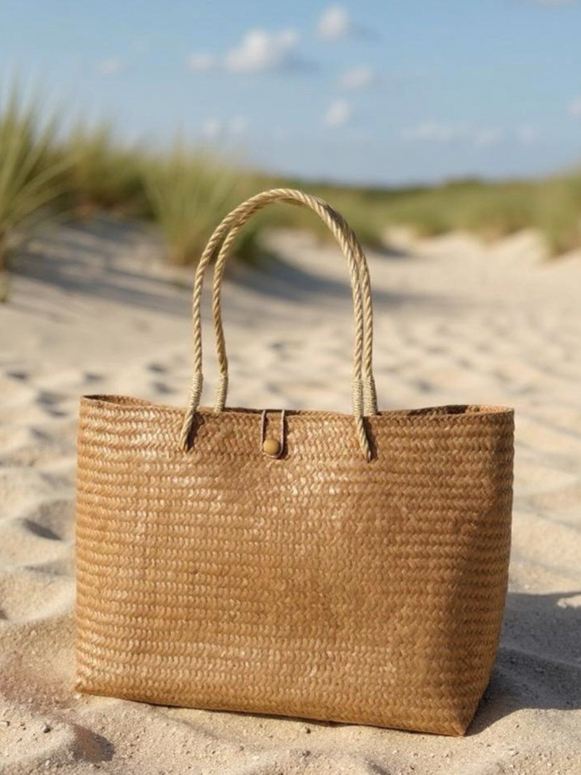 Oversized natural straw beach bag with button loop closure