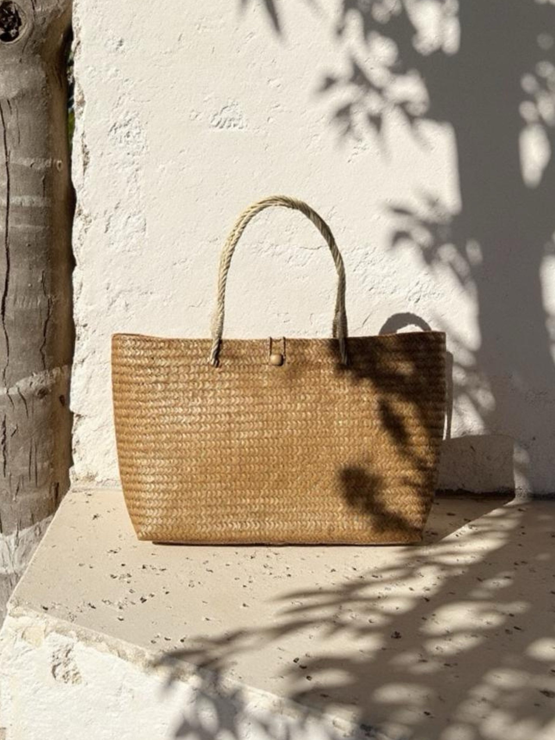 Oversized natural straw beach bag with button loop closure