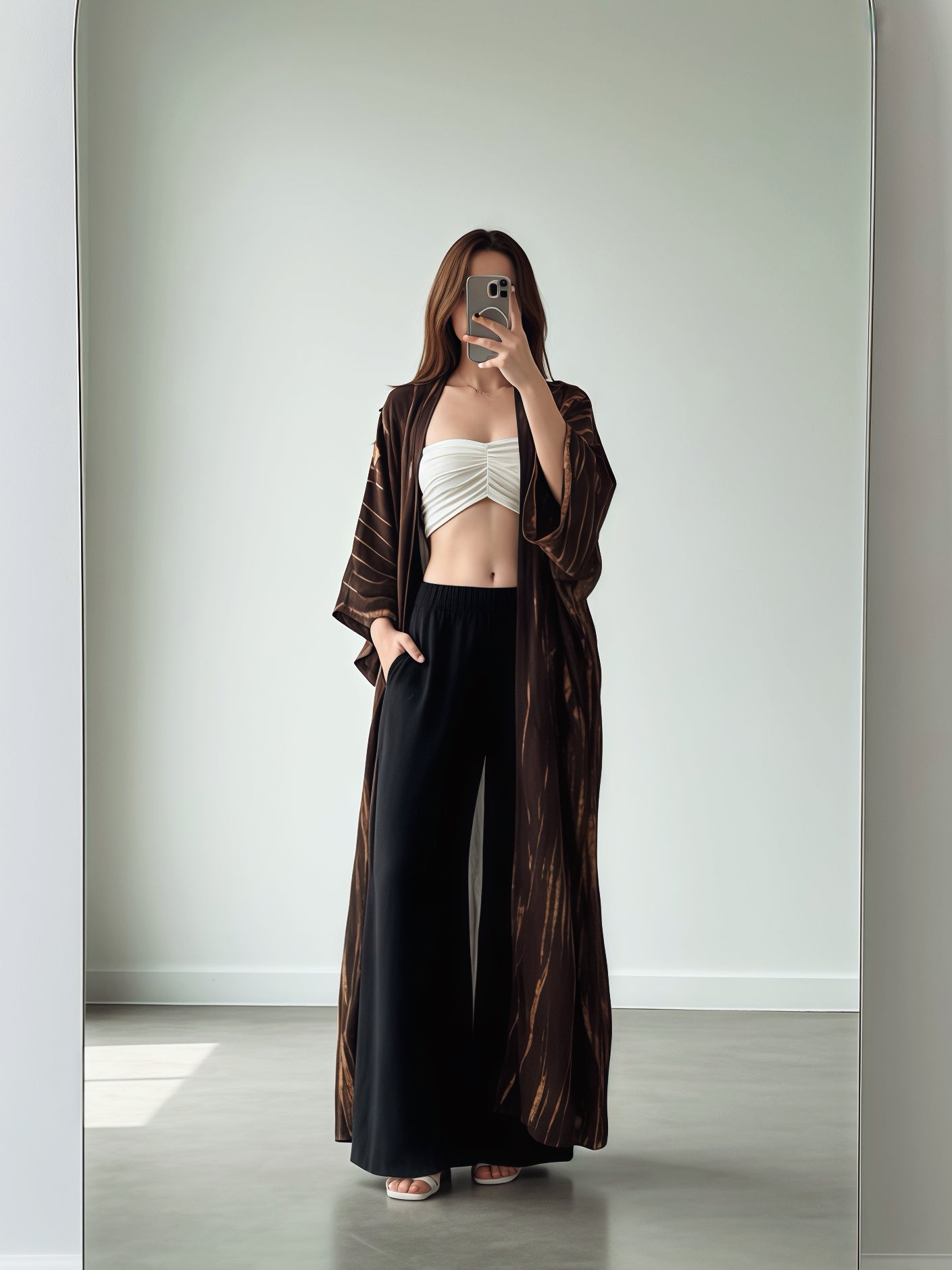 Woman lounging  in oversized boho tie dye kimono robe in brown, relaxed vacation boho look