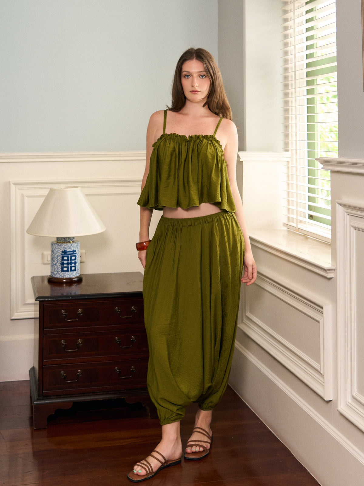 Full-length front view of Mira olive green harem pants styled with the matching top