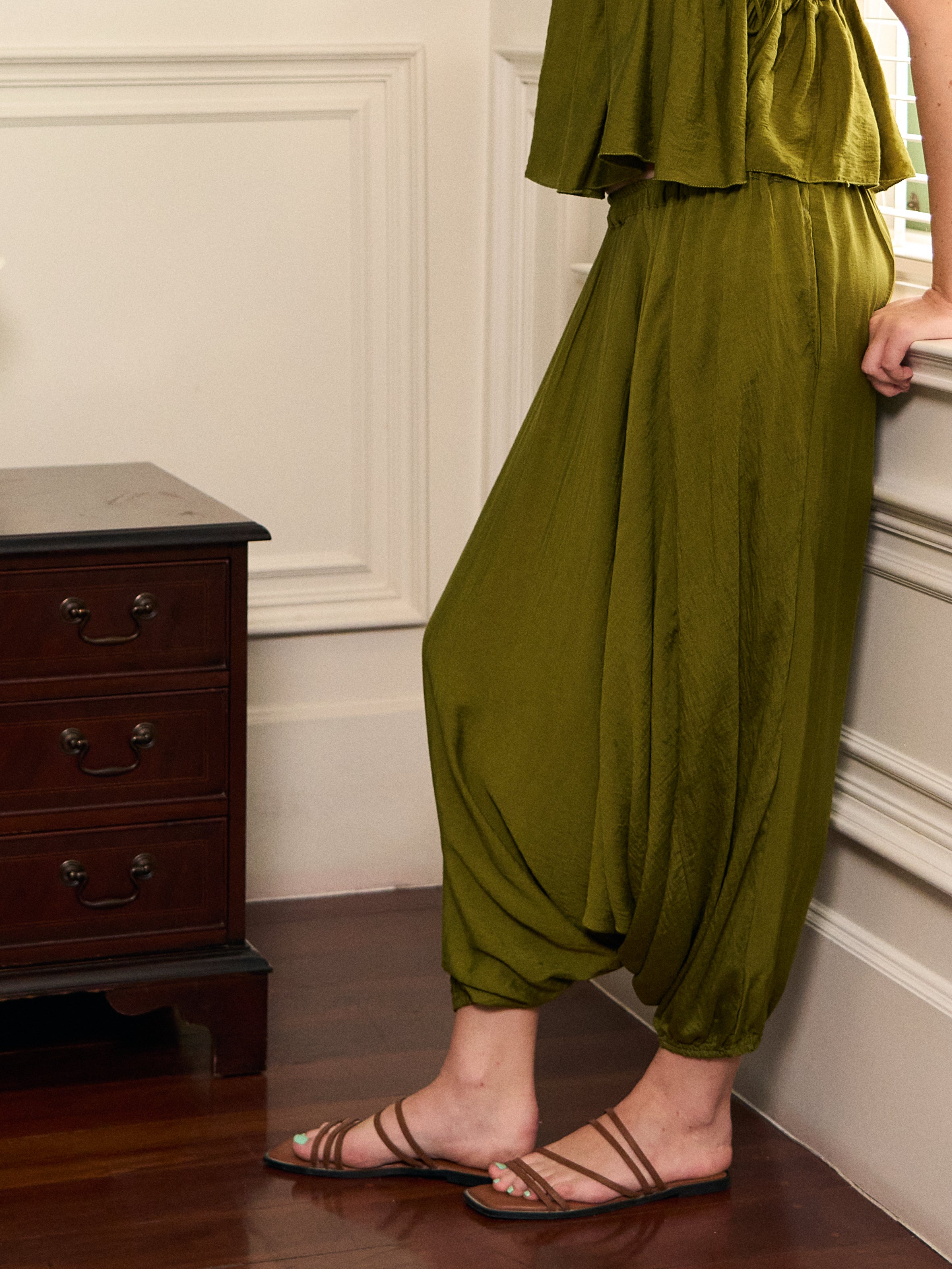 Close-up of Mira olive green harem pants showing the flowing drape and gathered elastic cuffs