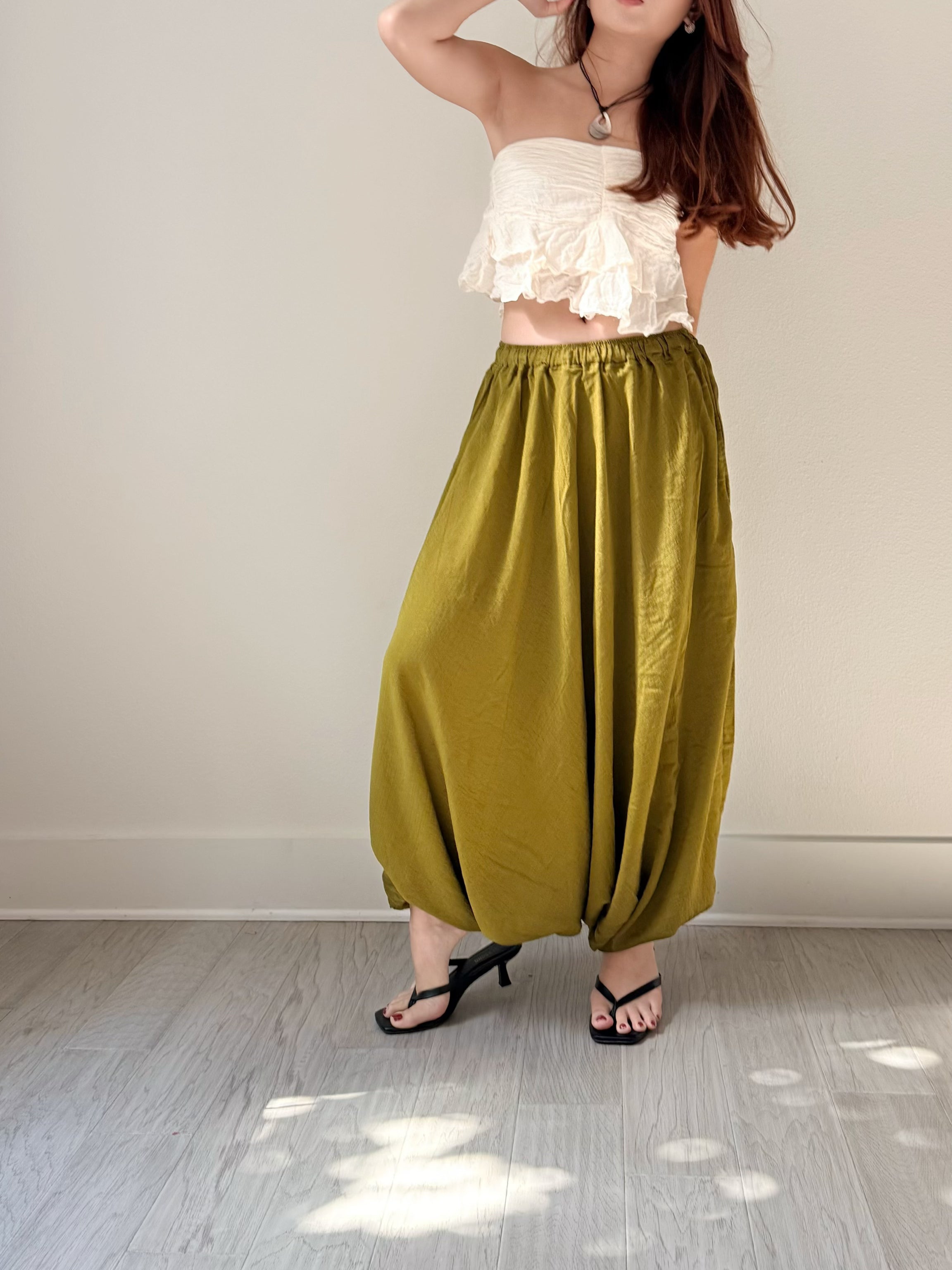 Mira olive green harem pants styled with a white strapless top and black heeled sandals