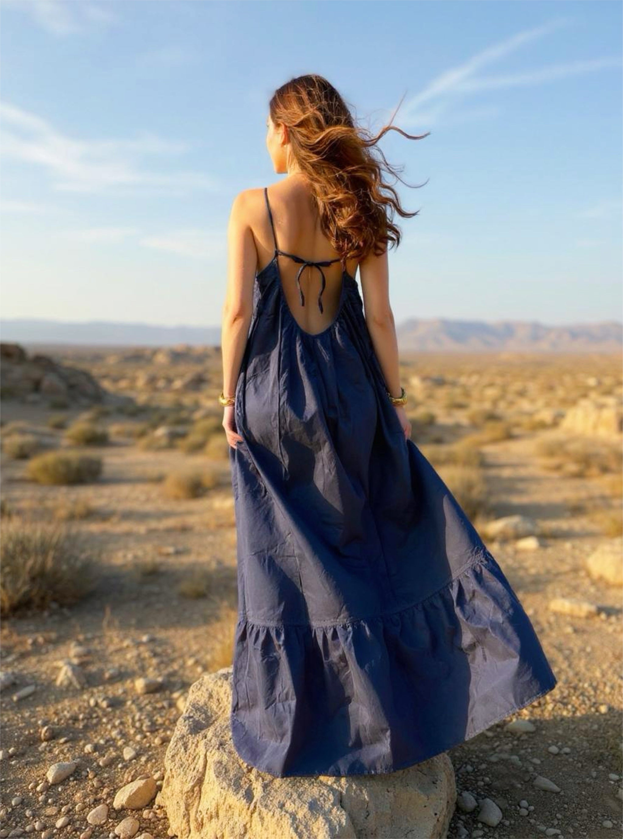 Back view of an oversized navy open-back maxi dress with ruffle hem and pockets, ideal for summer and resort wear.