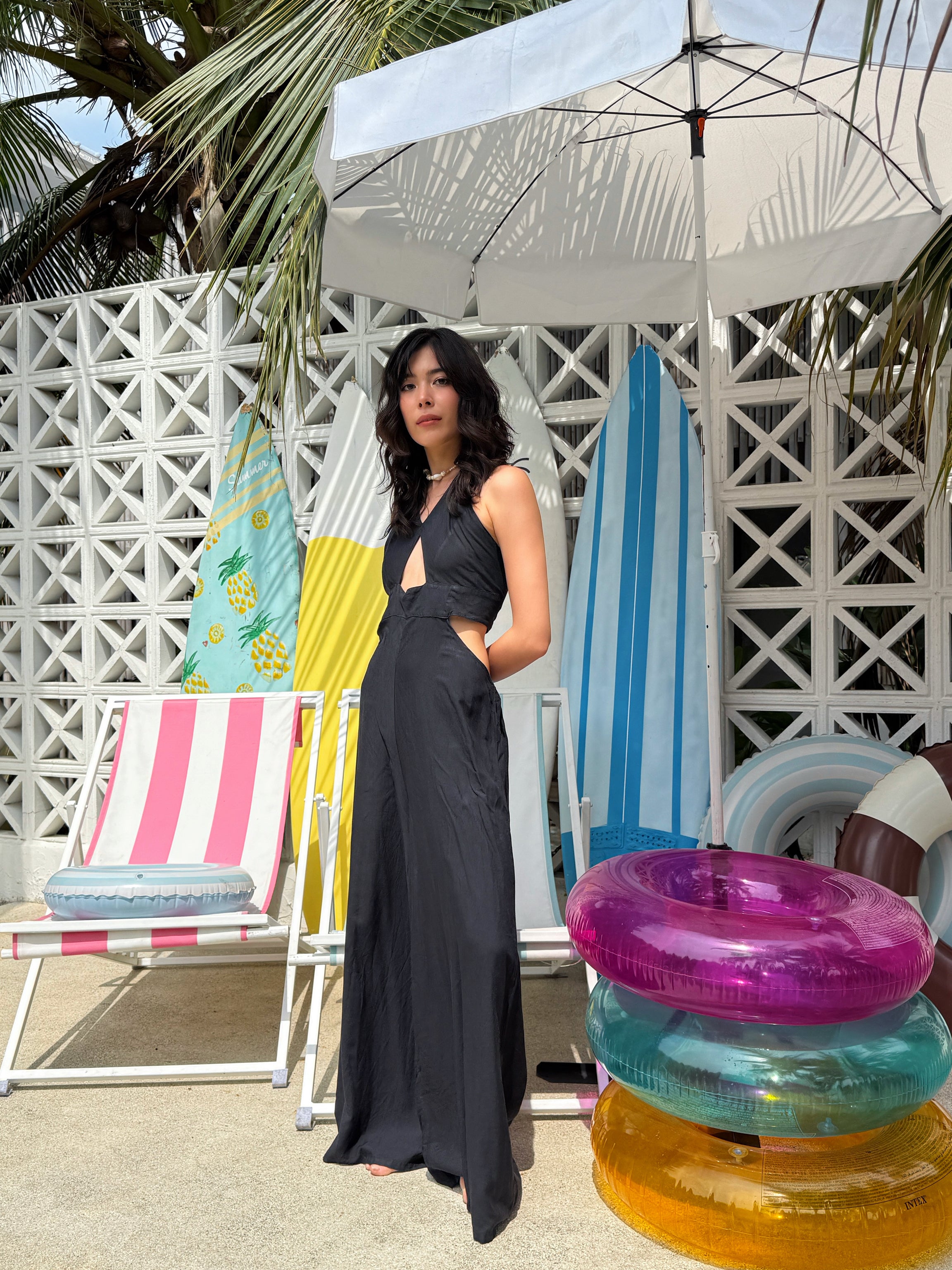 Model wearing black cut-out jumpsuit with wide legs and pockets – boho resortwear for summer holiday