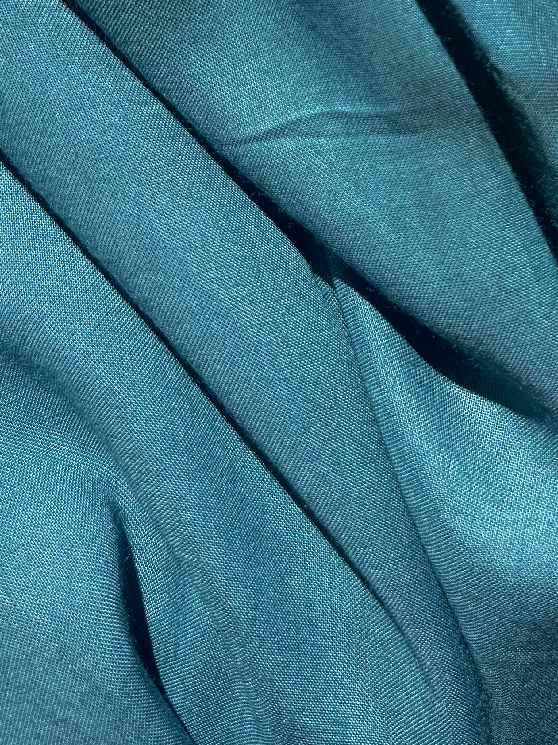 Teal kaftan dress and long caftan resort wear styled in a tropical beach villa.