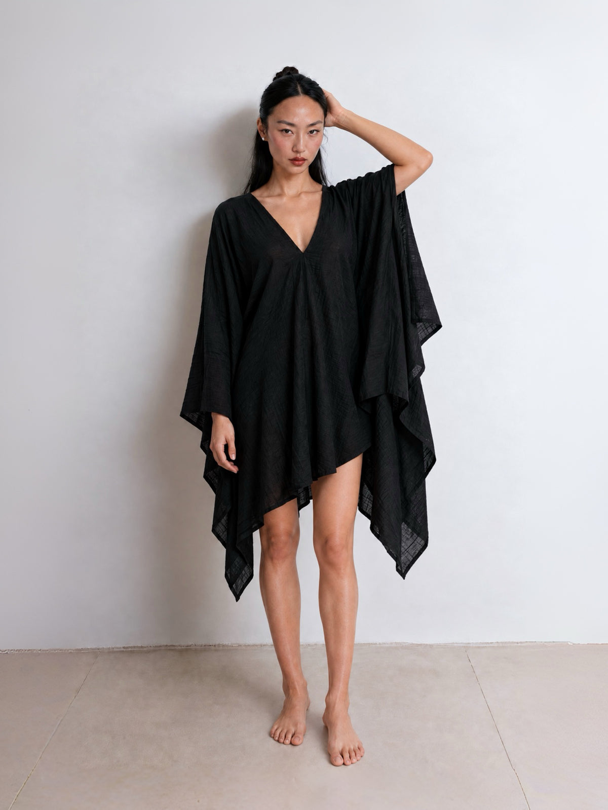 Show the back side of the black Soleil Mini Kaftan Cover Up with deep V neckline for resort wear.