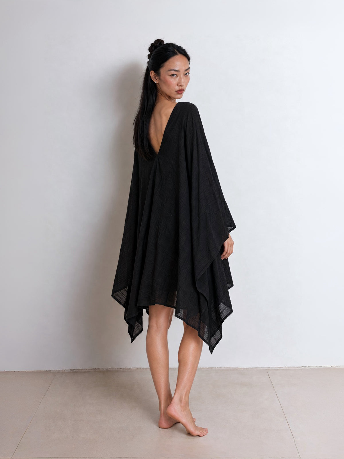 Show the back side of the black Soleil Mini Kaftan Cover Up with deep V neckline for resort wear.