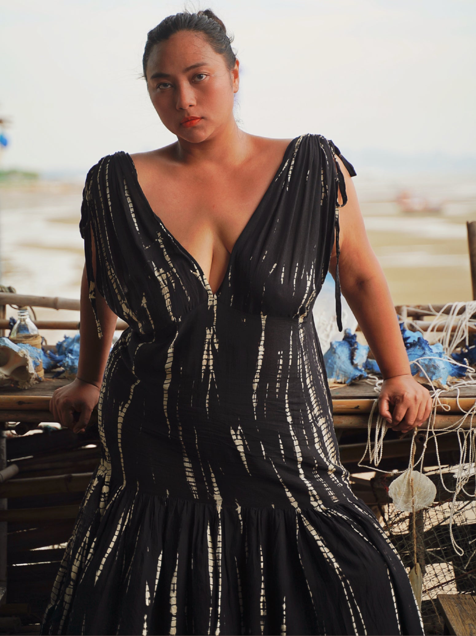 Model wearing a flowy, black tie-dye goddess kaftan dress with deep V-neckline and ruffled hem, handcrafted from soft rayon. Oversized boho kaftan designed for beachwear, resort lounging, or stylish everyday wear.
