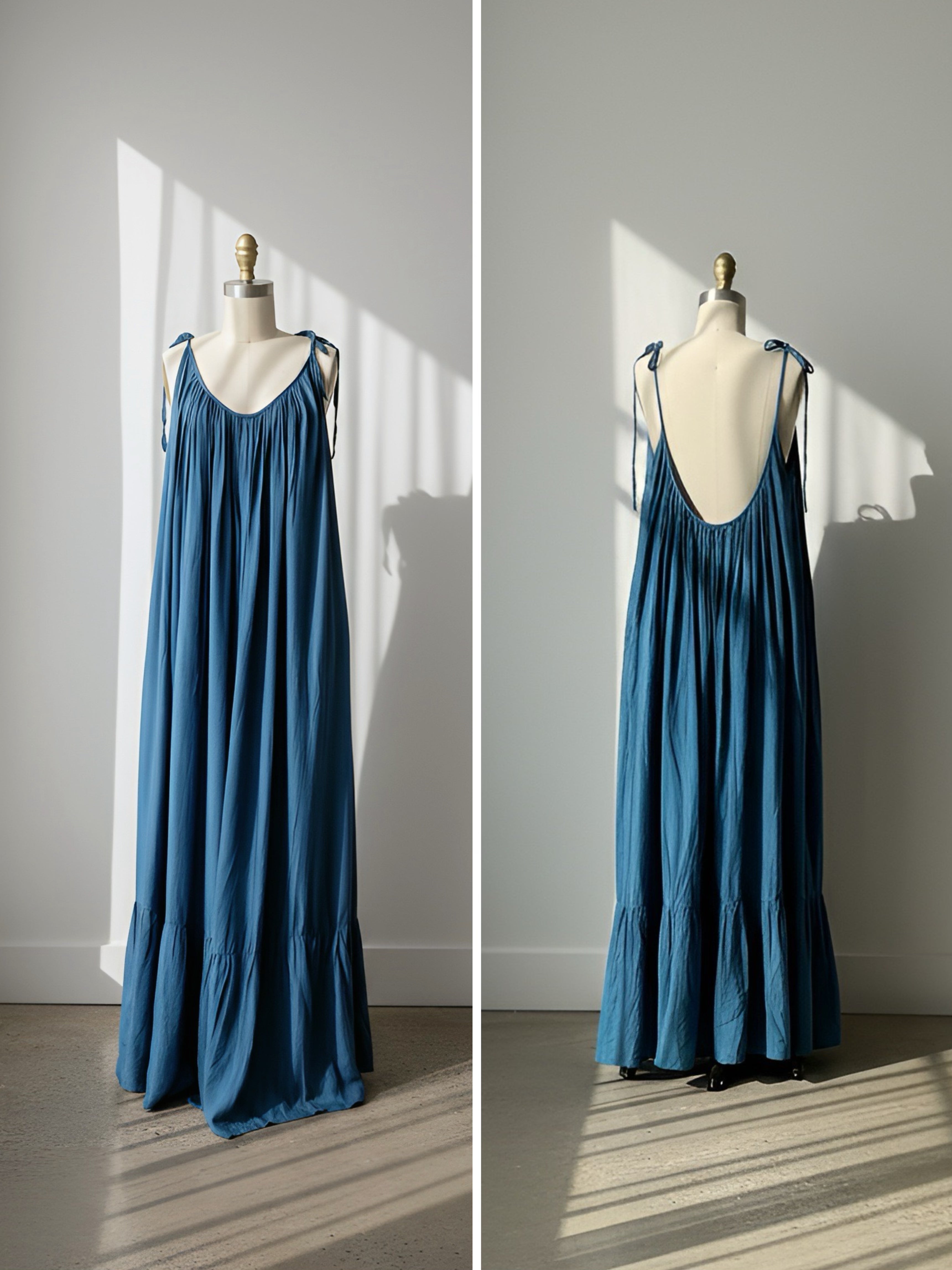 teal open back maxi dress on a mannequin against a white wall with sunlight casting shadows.