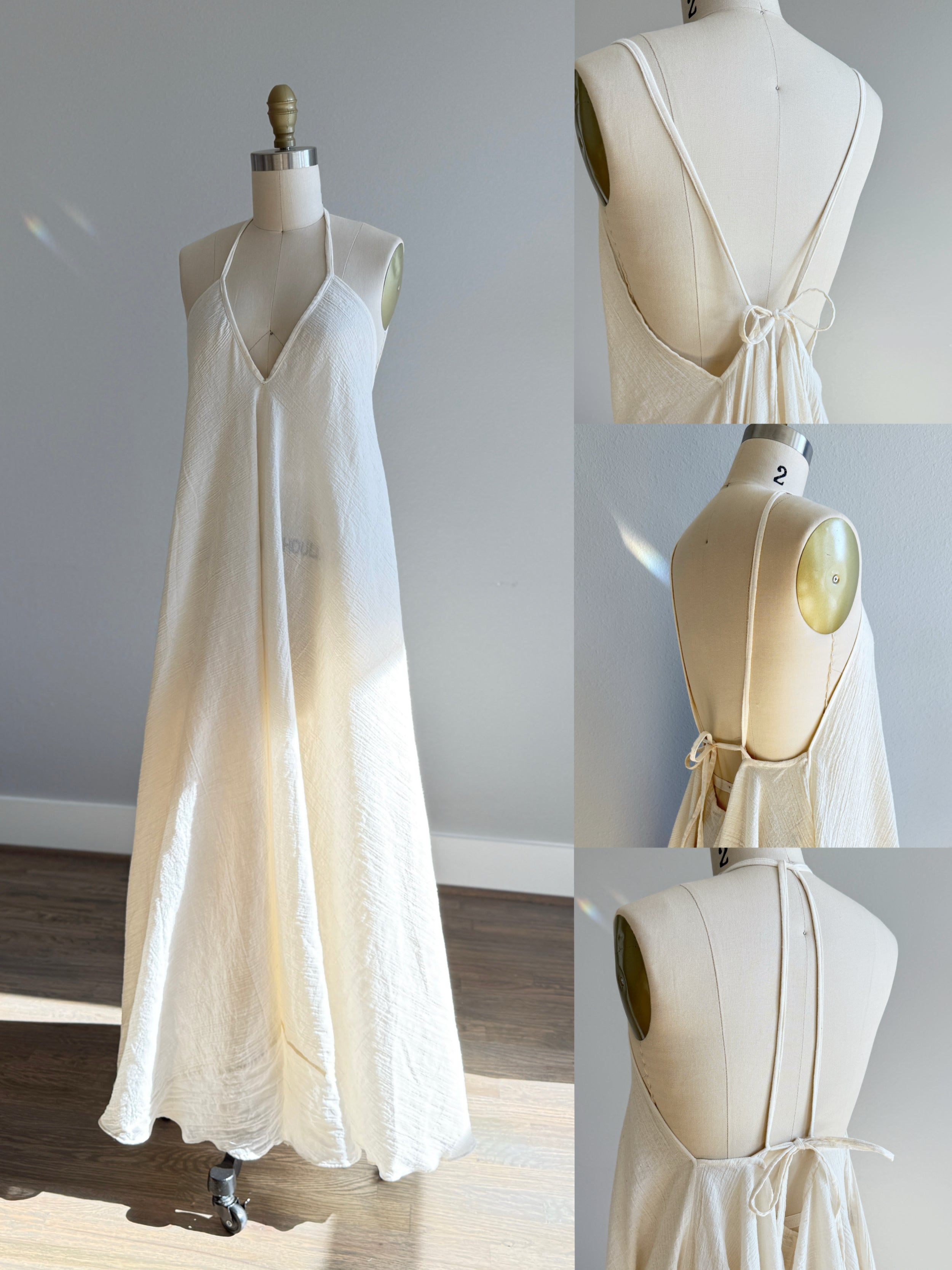 Ethically sourced organic cotton maxi dress displayed on a dress form, featuring a flowy A-line silhouette, deep V neckline, thin adjustable spaghetti straps, and a unique open back with tie detail. Handmade from raw, undyed cotton for a natural boho look, perfect as a beach dress or breezy summer weekend outfit.