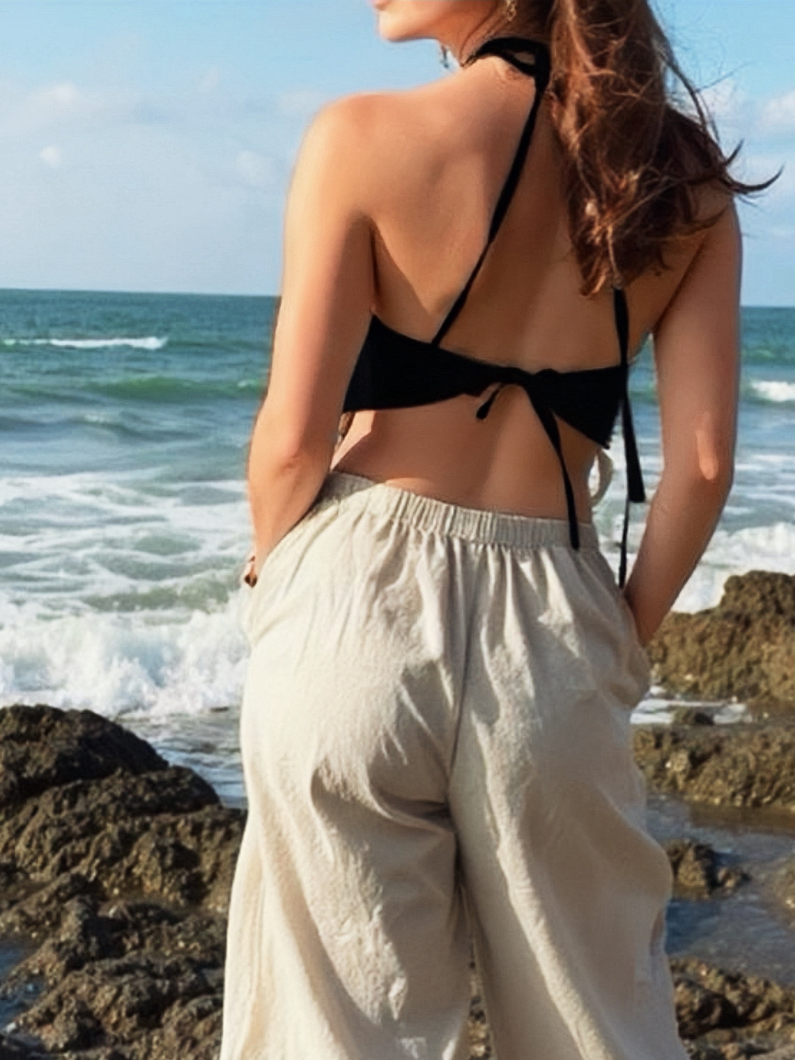 Model wearing natural hemp handkerchief halter crop top – sustainable boho festival and beach vacation outfit.