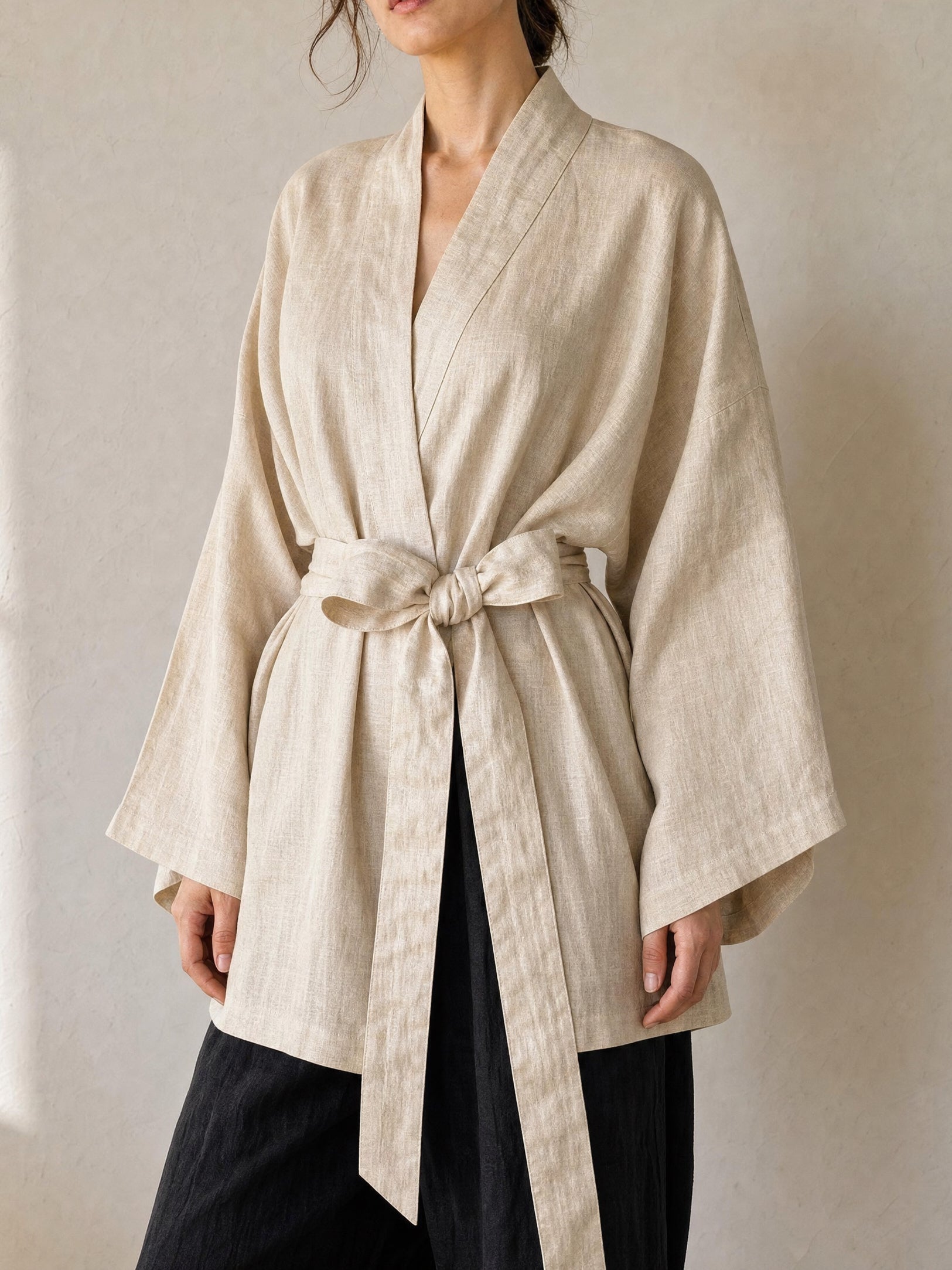 Natural cream linen kimono jacket with oversized wrap fit, wide sleeves, pockets, and removable waist tie, styled as a resort robe and everyday linen layer