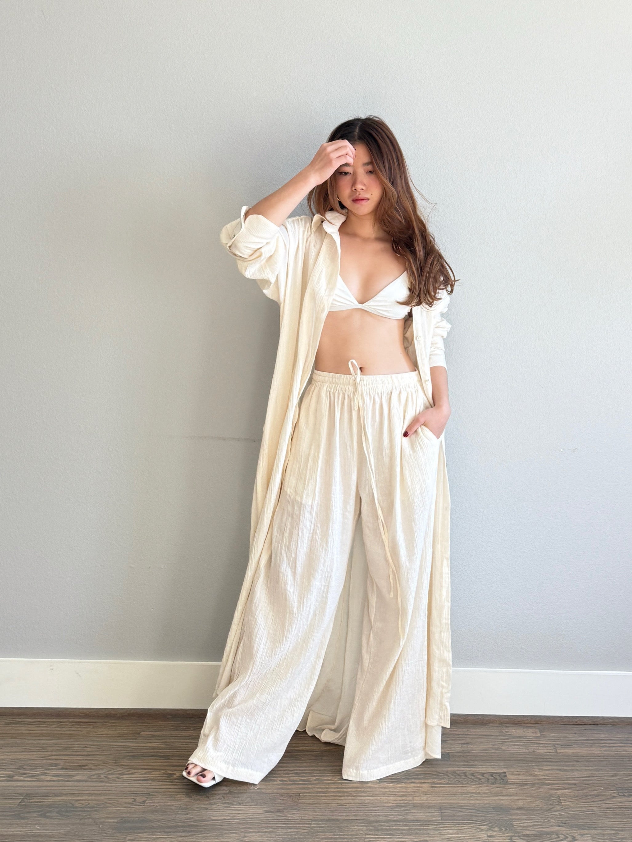 Model wearing organic cotton wide-leg pants with elastic waist, lightweight boho beach pants for summer and resort wear