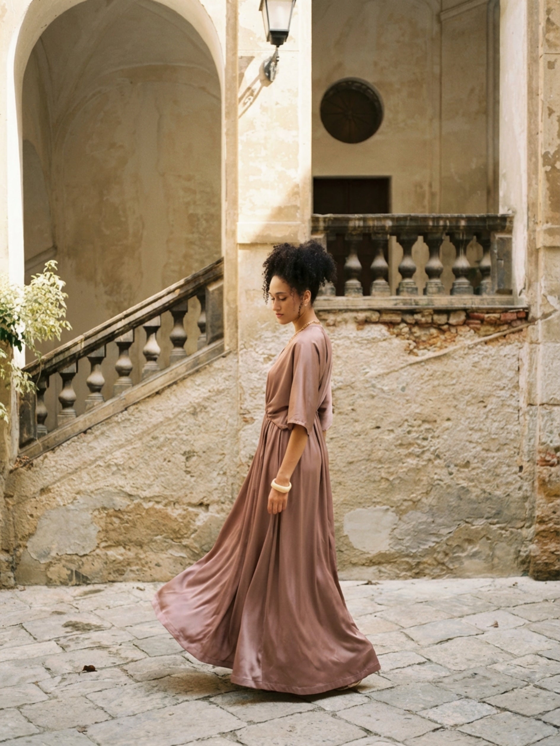 Woman wearing a kaftan maxi dress with deep V-neck and self-tie waist, styled as resort wear and a beach wedding guest dress by COCO DE CHOM