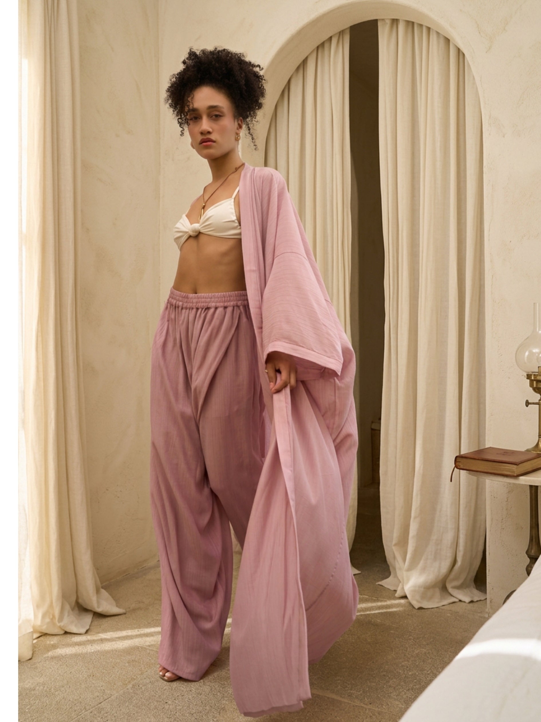 Woman wearing oversized mauve blush kimono kaftan as lightweight resort cover up, styled for beach and vacation wear by COCO DE CHOM