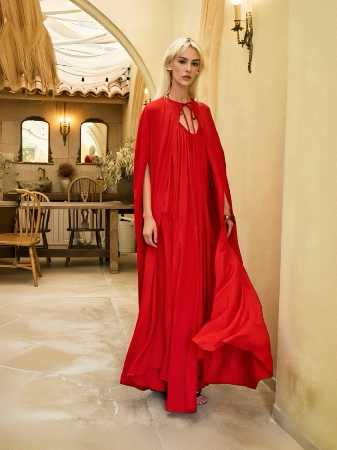 Woman in a red dress standing in a stylish interior setting