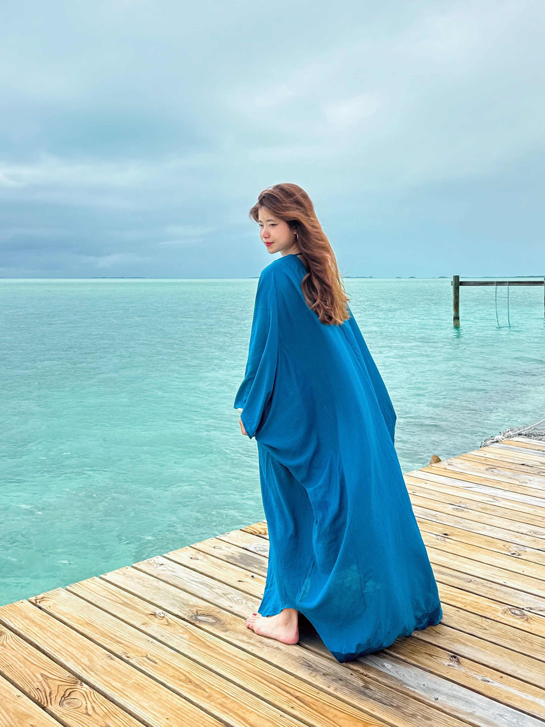 Woman wearing a teal blue Kaftan maxi dress, resort caftan maxi dress, beach cover up with relaxed sleeves and elegant drape—perfect for pool, beach, and cruise