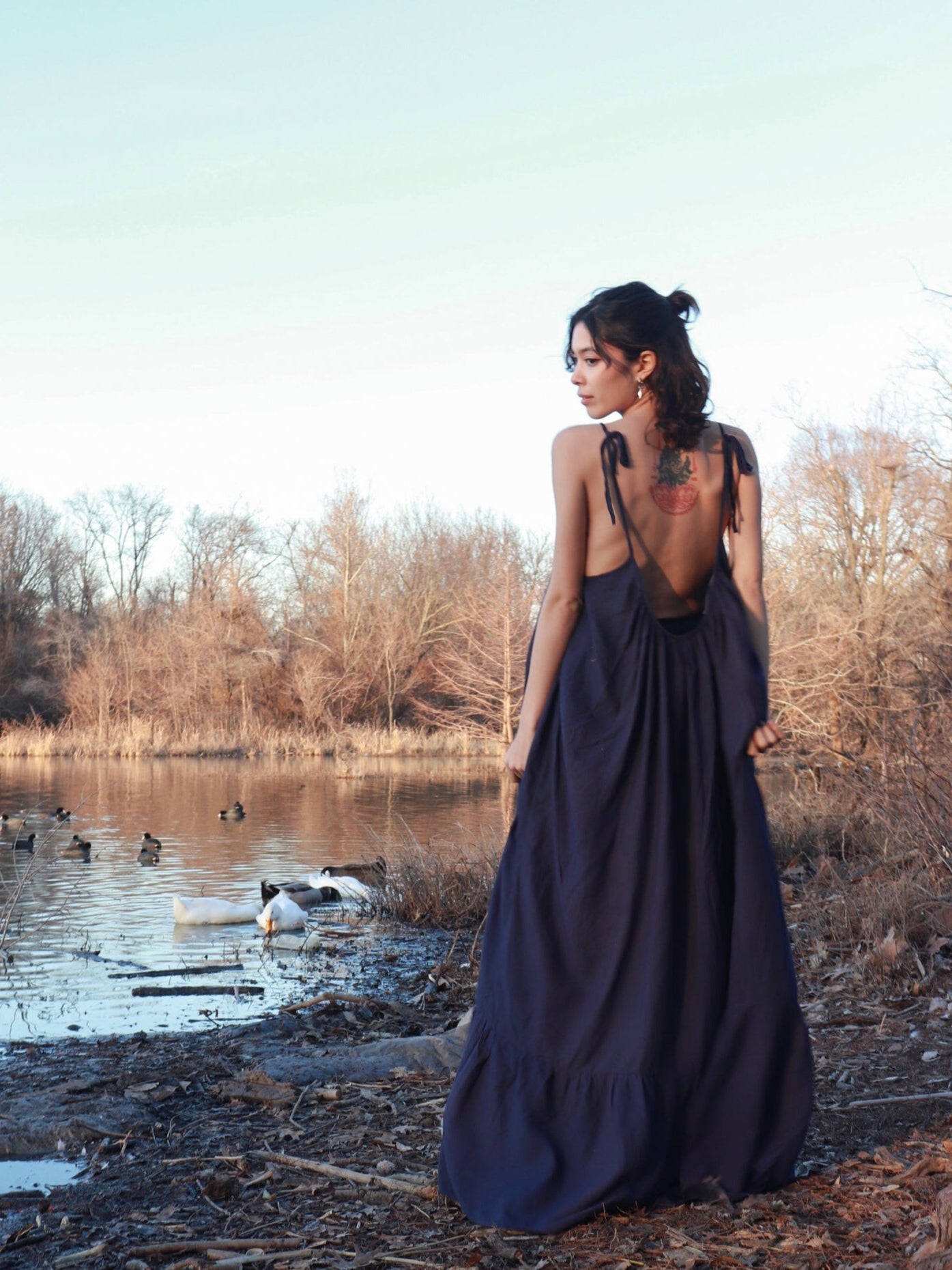 Back view of an oversized navy open-back maxi dress with ruffle hem and pockets, ideal for summer and resort wear.